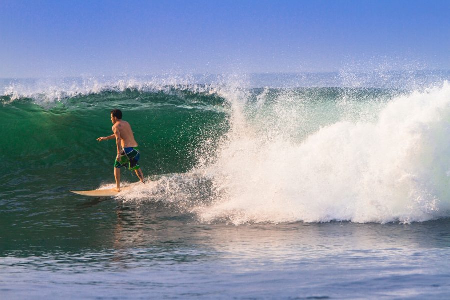 Surfer in a barrelling wave on beach in El Salvador.